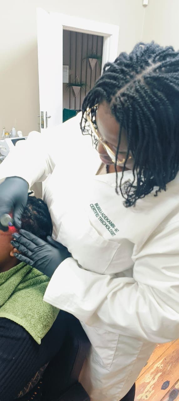 Certified trichologist performing professional scalp analysis and treatment